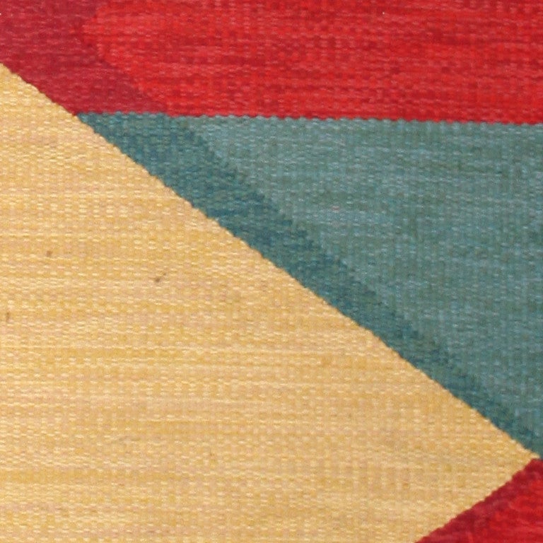 This magnificent antique Swedish Kilim features a phenomenal geometric composition comprised of many distinct patterns and components. The precisely drawn field showcases an assortment of broad stacked lozenges with zigzagging accordion-fold