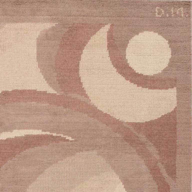 A classic modernist pattern of intersecting circles and crescents in shades of mauve, taupe, sand, and cocoa unfolds dynamically across the field of this grand Art Deco carpet. The understated monochrome border allows the design to dominate the
