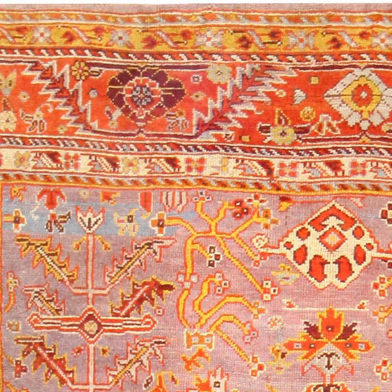Antique Turkish Oushak Rug, Turkey, circa 1900 -- A fascinating interplay of gold, orange and deep red hues characterize this cheerful and lively antique Turkish Oushak rug. Playful abstract and floral bands frame the central design, with a thick