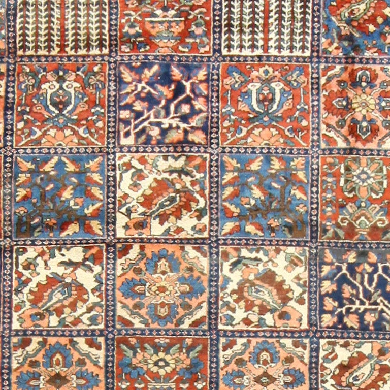 Antique Bakhtiari Rug, Persia, Circa 1920 -- A wide border of blue frames the quilt-like blocked pattern of this antique Persian Bakhtiari rug, circa 1920. The use of detail coupled with the specific tones of blues and rich browns in this piece are