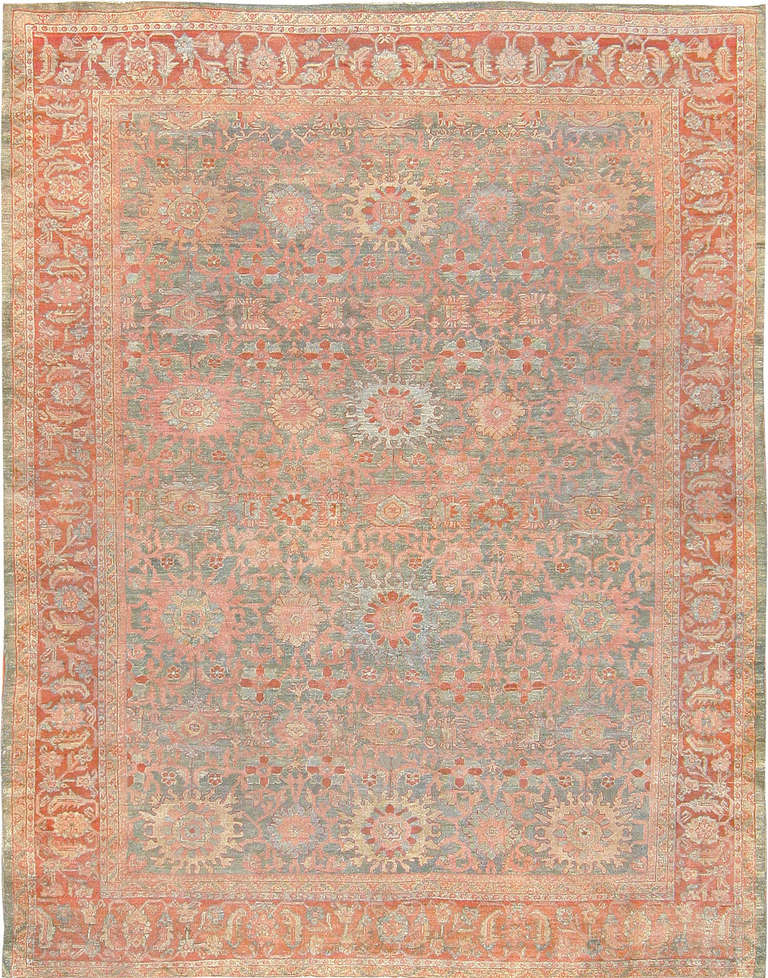This truly impressive antique Persian Sultanabad rug is characterized by a gorgeous, classical design of floral design elements, with a series of spirallin vine scrolls offering their support. A masterful border, also resplendent with elements of