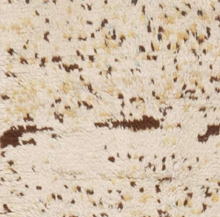 This abstract rug is decorated with a random allover pattern incorporating a series of colorful specks and freckles rendered in a restrained combination of buttery yellow and walnut brown paired with subtle green and robin's egg blue accents.