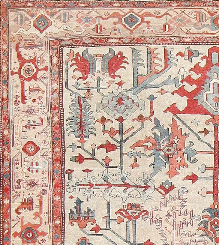 Here is an absolutely stunning antique Oriental rug - an antique Heriz Serapi composition, woven in Persia during the latter years of the nineteenth century. This astonishing tribal rug is primarily characterized by its sumptuous ivory field,
