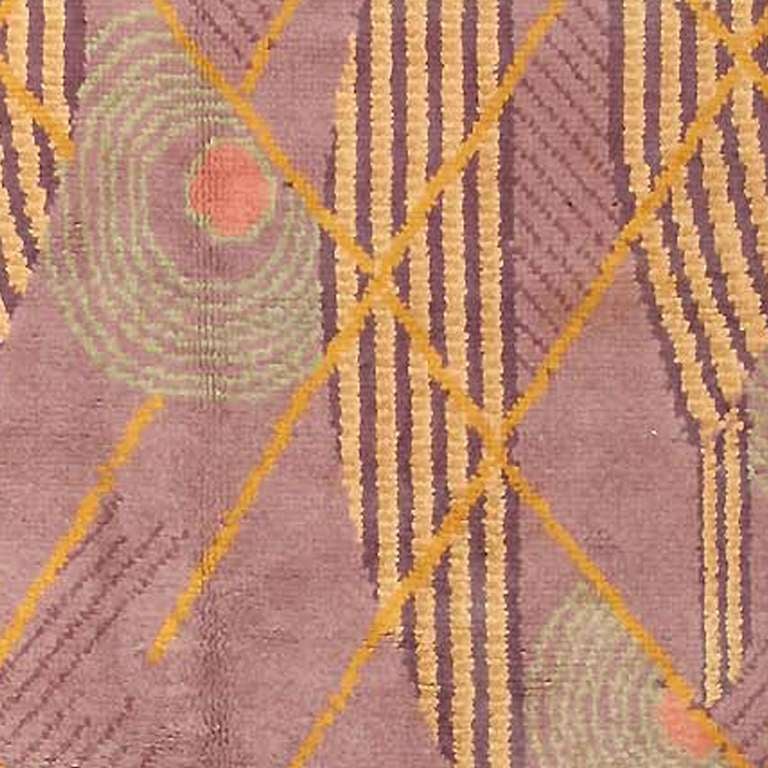 Art Deco Rug, circa 1920's This stunningly classic Art Deco carpet revels in the beauty of pure geometry and exquisite color. Sections of circles articulated with parallel and concentric lines float across the mauve-lavender field, ensnared so to