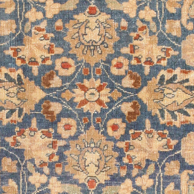This magnificent antique Persian Khorassan carpet features a splendid allover arabesque rendered in an eternally elegant combination of royal blue and sophisticated earth tones. Multiple sets of heavily patterned borders encircle the beautifully