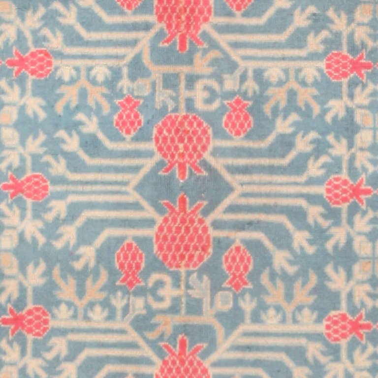 Towers of splendid interlaced pomegranate shrubs traverse this luxurious antique Khotan carpet and create a magnificent allover pattern. The opulent composition is charming, colorful, superbly decorative and possesses all the traits of an ideal
