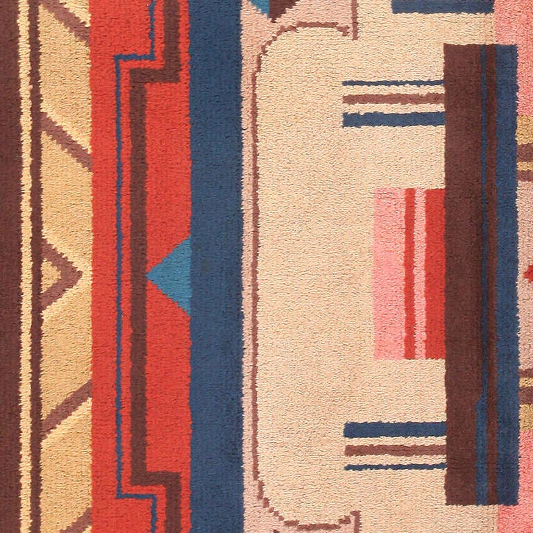 Embracing the novel style of the 20th century, this vintage Swedish carpet showcases a flamboyant ladyfinger medallion with sweeping curves and Art Deco lines. Sharp right-angle figures with bright high-chroma monotones are expertly arranged in a