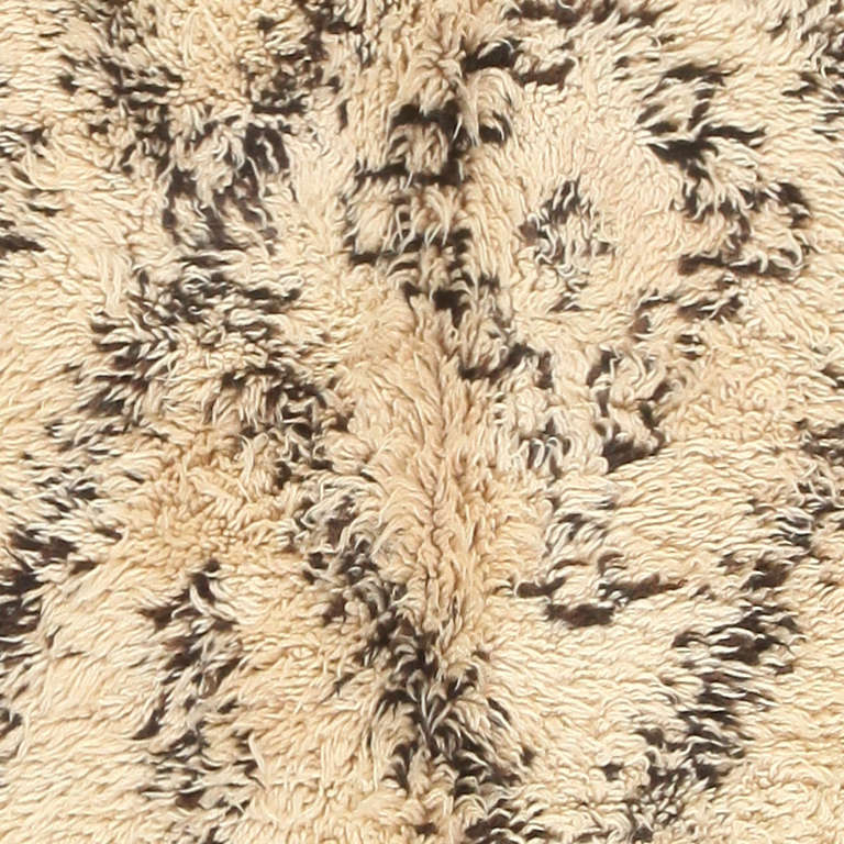 This exemplary Moroccan pile carpet embodies all of the marvelous traits that make these regional masterpieces essential design pieces for mid-century interiors. It has the versatile achromatic color palette, luxurious textures and enigmatic tribal