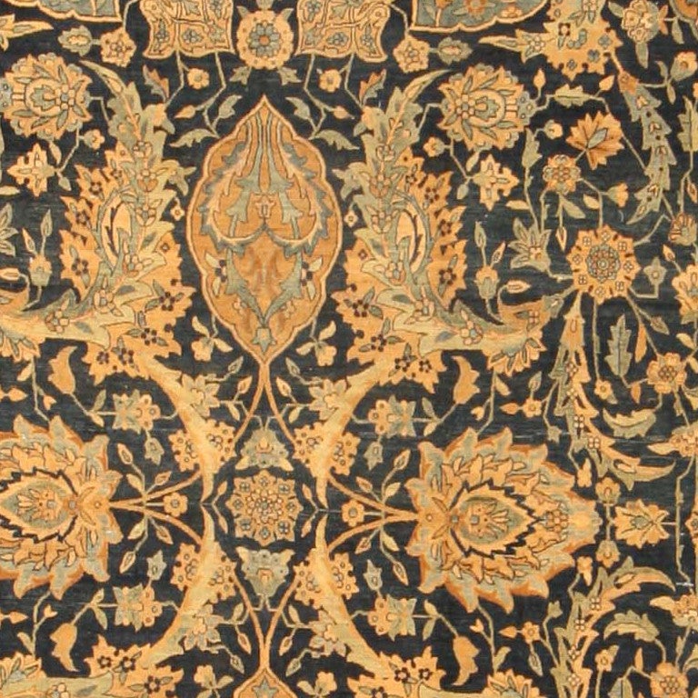 This  aristocratic Kerman is exceptional for the grand scale and the stately presence of  its classical Persian design. At the center a quatrefoil of four linked palmettes anchors a larger array of swirling vines, palmettes, medallions leafy sprays