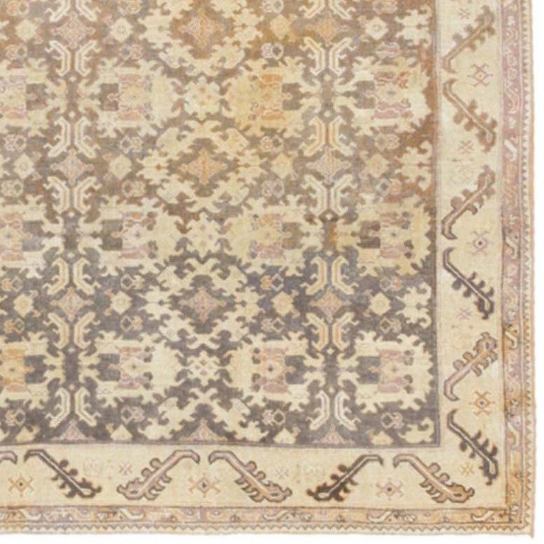 Bordered by a reciprocating pattern of snake-like motifs over a sparse ivory field, this elegant carpet from Agra features a series of repeating Mina Khani-style medallions reminiscent of patterns from western Persia and the Caucasus, including