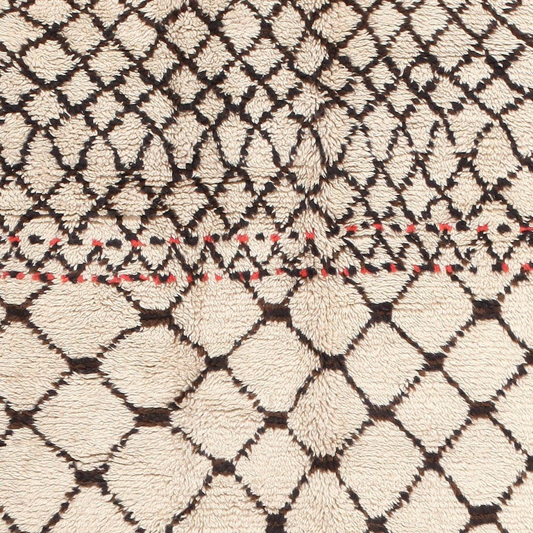 The expansive linear decorations, the crisp achromatic colors and the superb textures featured in this vintage Moroccan rug typify the Mid-Century era. This chic Moroccan rug depicts a refined latticework pattern with bold rectilinear intersections