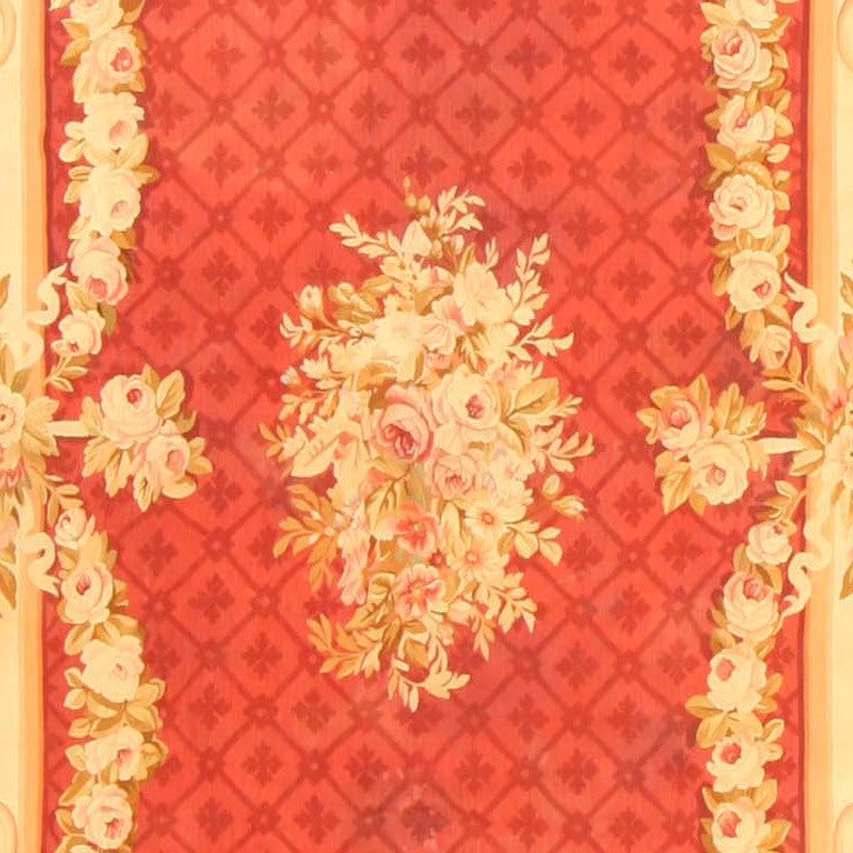 Six oval cartouches punctuate the grand ivory frame of this luxuriant Aubusson. Garlands appear to sway from the frame into a deep cinnamon central field with a delicate allover lattice and central bouquet. This carpet displays that masterful