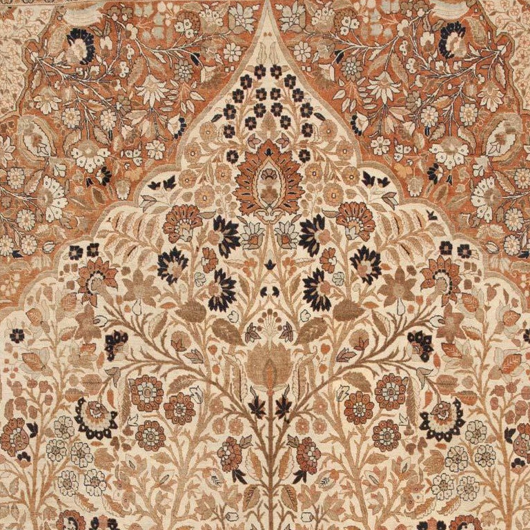Fantastically detailed, this superlative antique Persian Tabriz rug takes the traditional Tree of Life composition to an unimagined level of beauty. The soft ivory-colored field is decorated with a towering Tree of Life vase surrounded by decorative
