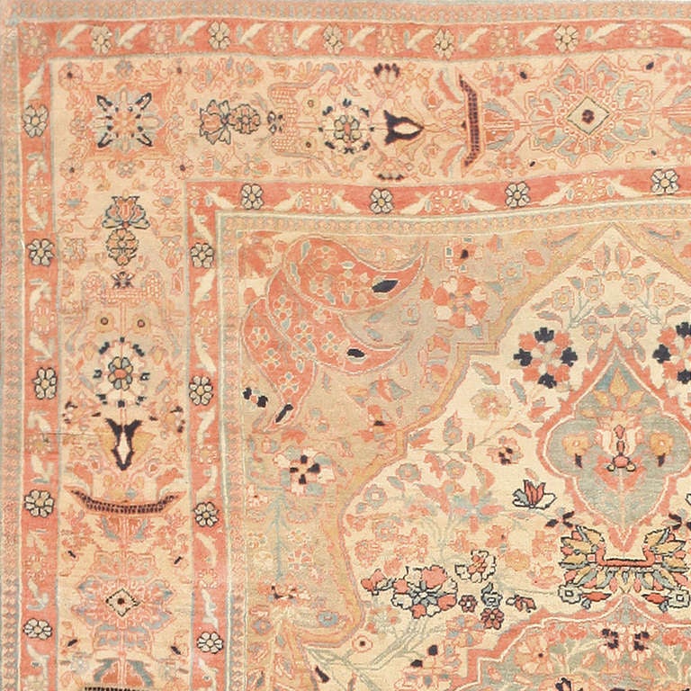 Striking in its soft colors and ornate floral decorations, this antique Persian Kashan carpet displays a wealth of iconic Mohtashem decorations rendered in an airy, surprisingly feminine color scheme. Expressing the atelier's talent for complex