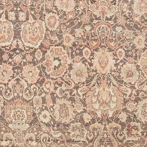 This exquisite carpet features a dense, all-over arabesque woven in a striking combination of neutral colors. Ornate palmettes and cloudbands connected by an interwoven network of sinuous vinescrolls contrast strongly against the dark brown