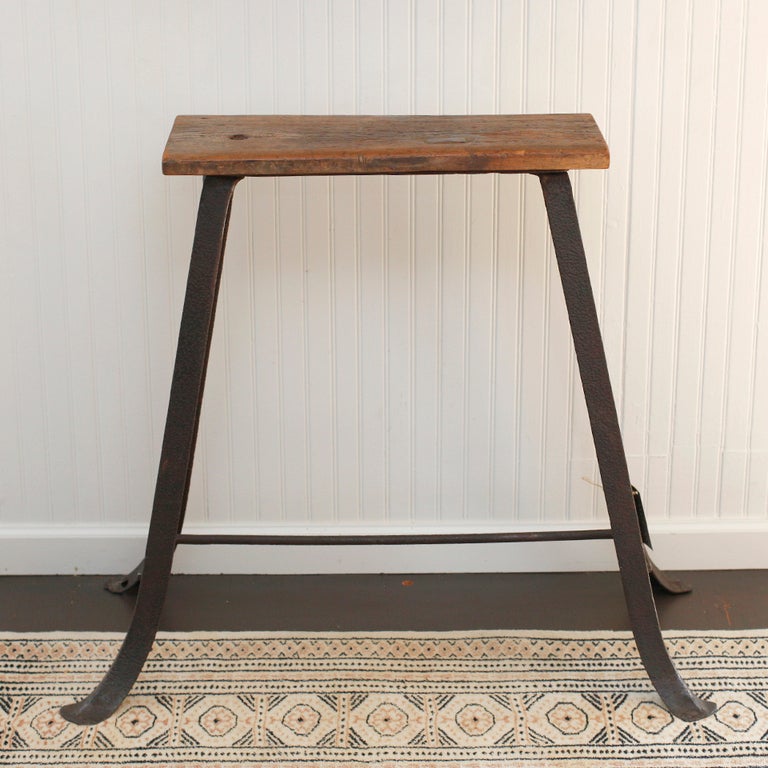 Early 20th century metal and wood stand. Elegantly splayed metal legs support a single plank of patinaed wood.
