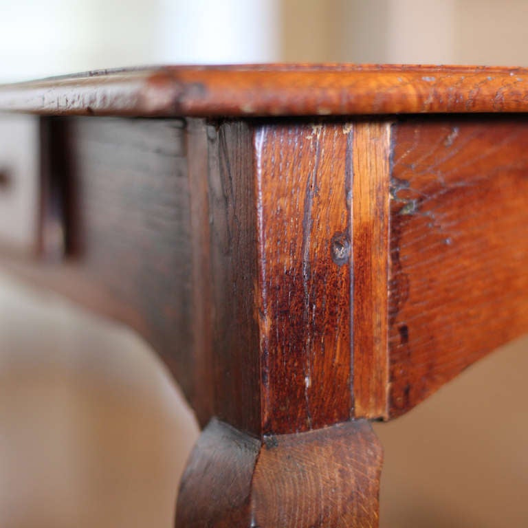 An 18th century French oak side table. Gently curving cabriole legs, with a doweled top and single drawer.