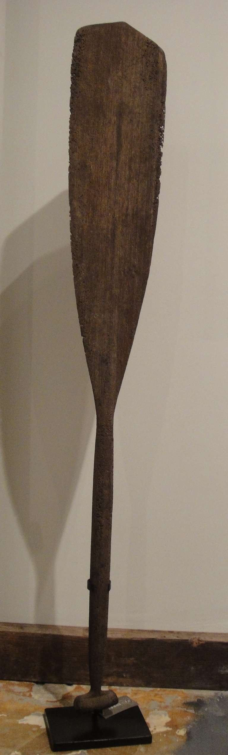 This vintage oar on stand was reclaimed from the ocean. Found in Indonesia, probably originally made in the early 20th century from iron wood.
