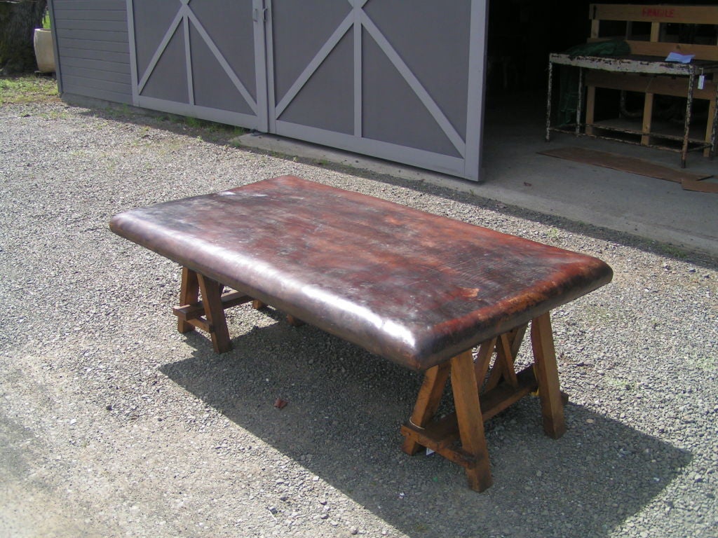 1940's gymnast mat. Leather top with saw horse legs. Some green paint which has transfered to one edge of the mat. Solid construction saw horse legs. The mat could be mounted as a head board for a bed.