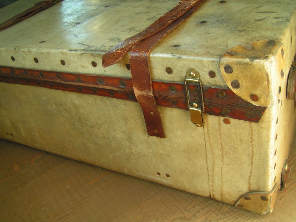 Wonderful vellum Harrod's trunk with leather corners, wood slat bottoms and leather straps.  Harrod's tag is sewn in and this has the top shelf and all the straps up and down.