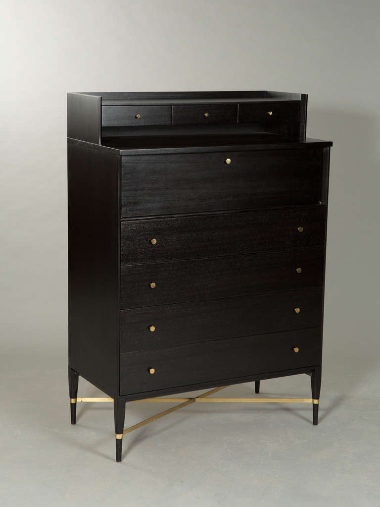 Ebonized Mid-Century tall chest of drawers/secretary with 6 concealed drawers behind drop down door designed by Paul McCobb for Calvin Group. Brass knobs and 