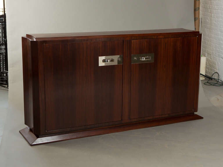 Streamlined Ruhlman style rosewood Art Deco sideboard with polished nickle hardware. Interior shelves and pair of drawers. Included 2 keys.