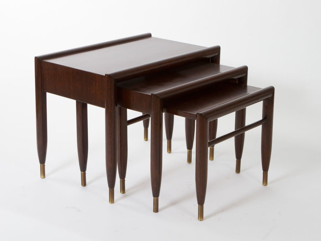 Trio of mahogany nesting tables with brass end caps designed by John Keal for Brown-Saltman . Excellent restored condition.<br />
Large table - 19