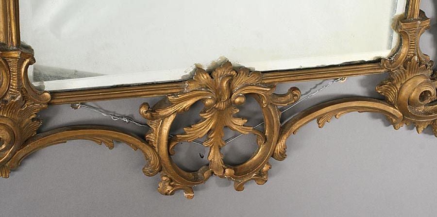 Grand et impressionnant miroir biseauté ancien avec cadre orné de décorations en or peint et plaque de miroir ancienne.