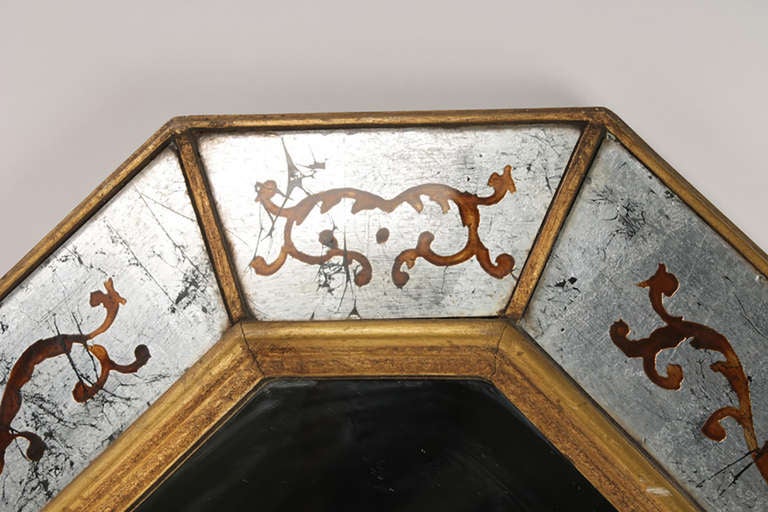 Jansen eglomeise decorated mirror with silver gilt and gilt reverse decorated eglomise panels.