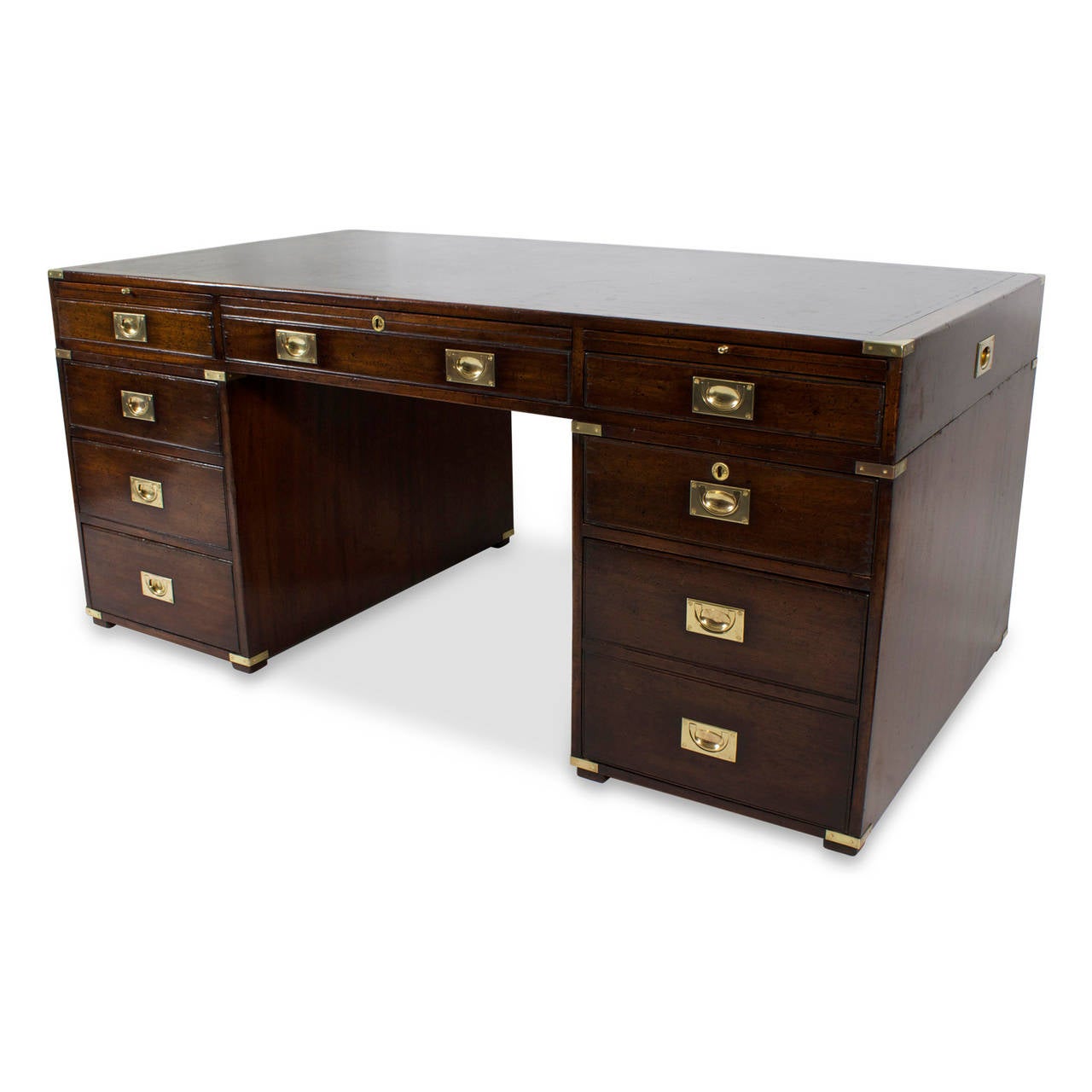 A vintage, English mahogany three-piece Campaign style desk, featuring bookshelves on the reverse, a tooled leather top with time-worn patina, original brass hardware, retractable trays, and nine storage drawers filled with history and secrets.