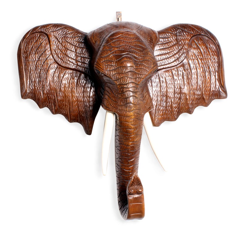 A large carved elephant head with incredible detail. Teak with painted white tusks.

fshenemaderantiques.com for more very interesting pieces.