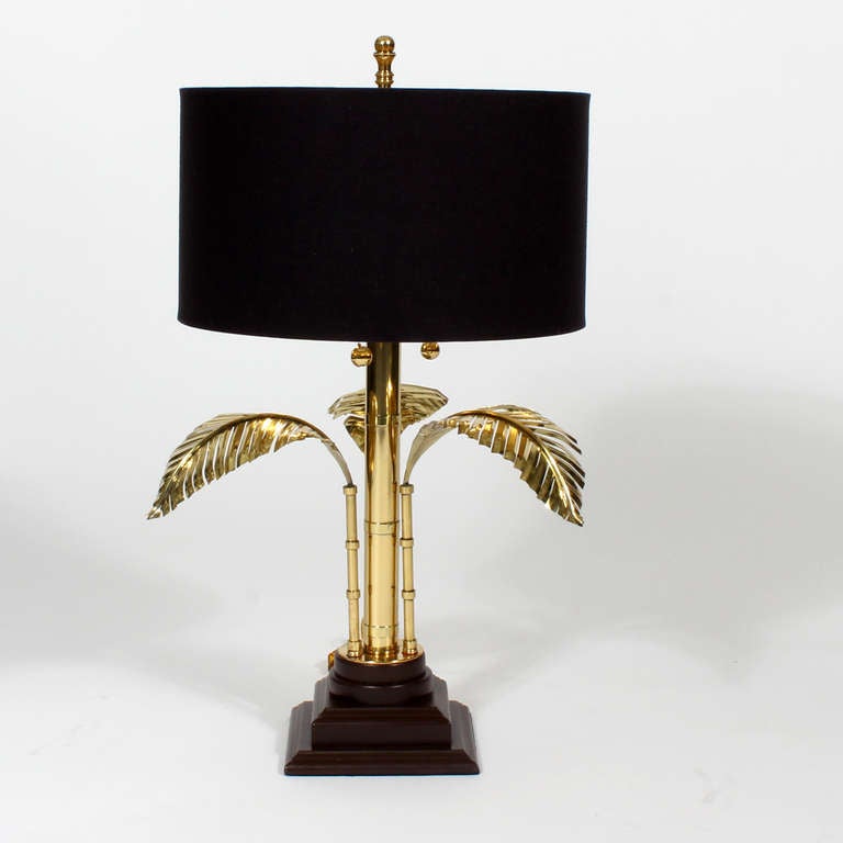 A pair of palm tree motif table lamps, in brass with stepped wood bases. 3 tropical fronds surround a central brass rod. Newly wired. Very attractive lamps.