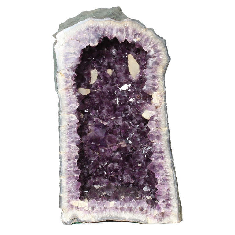 A large polished amethyst crystal geode, with excellent color and depth to the crystals. Heavy, but manageable.
 

