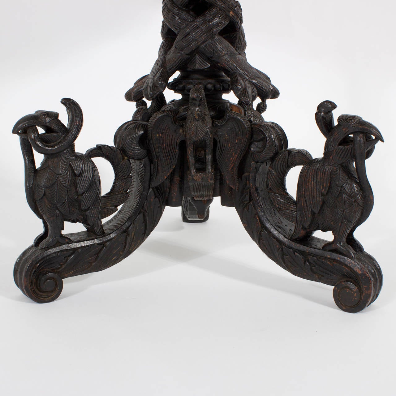 Impressive, antique Anglo-Indian occasional table with an elaborately carved three-leg pedestal base with scrolled feet, birds, snakes and foliage supporting a intricately carved circular top with foliage, birds, elephants and such, surrounded by a