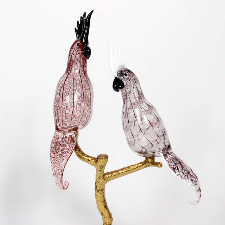 Two large hand blown glass parrots sit on top of a gilt iron branch, terminating in a glass base, signed Zanetti.  This is a large and beautiful sculpture, which breaks down into 4 pieces, for ease of transport.

Vintage and more at