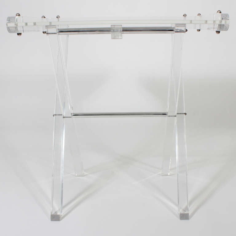 A large clear lucite butlers tray with chromed metal details, thick lucite legs and frosted tray. Easily collapsible and very decorative. Works well as a desk, table or tray.
