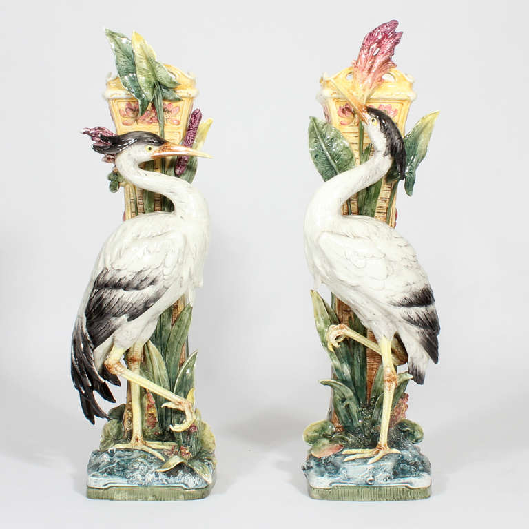 This is a pair of very impressive majolica bird vases, with storks, herons or cranes, set against a bull rush background, with supported by a large yellow column, decorated on the reverse with water lilies or similar. Beautiful condition, with light