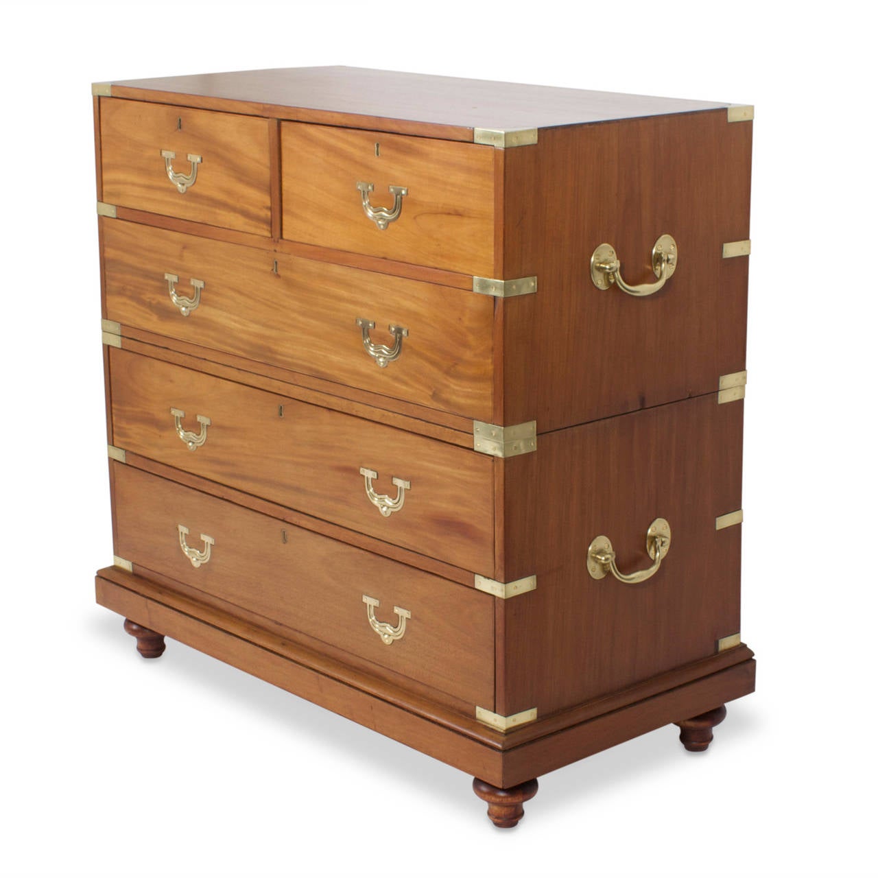 Rare camphor wood, antique chest of drawers with classic Campaign form, featuring brass hardware, dramatic wood grain, recessed pulls and raised on turned feet. Ready to be used for another hundred odd years. Newly polished.