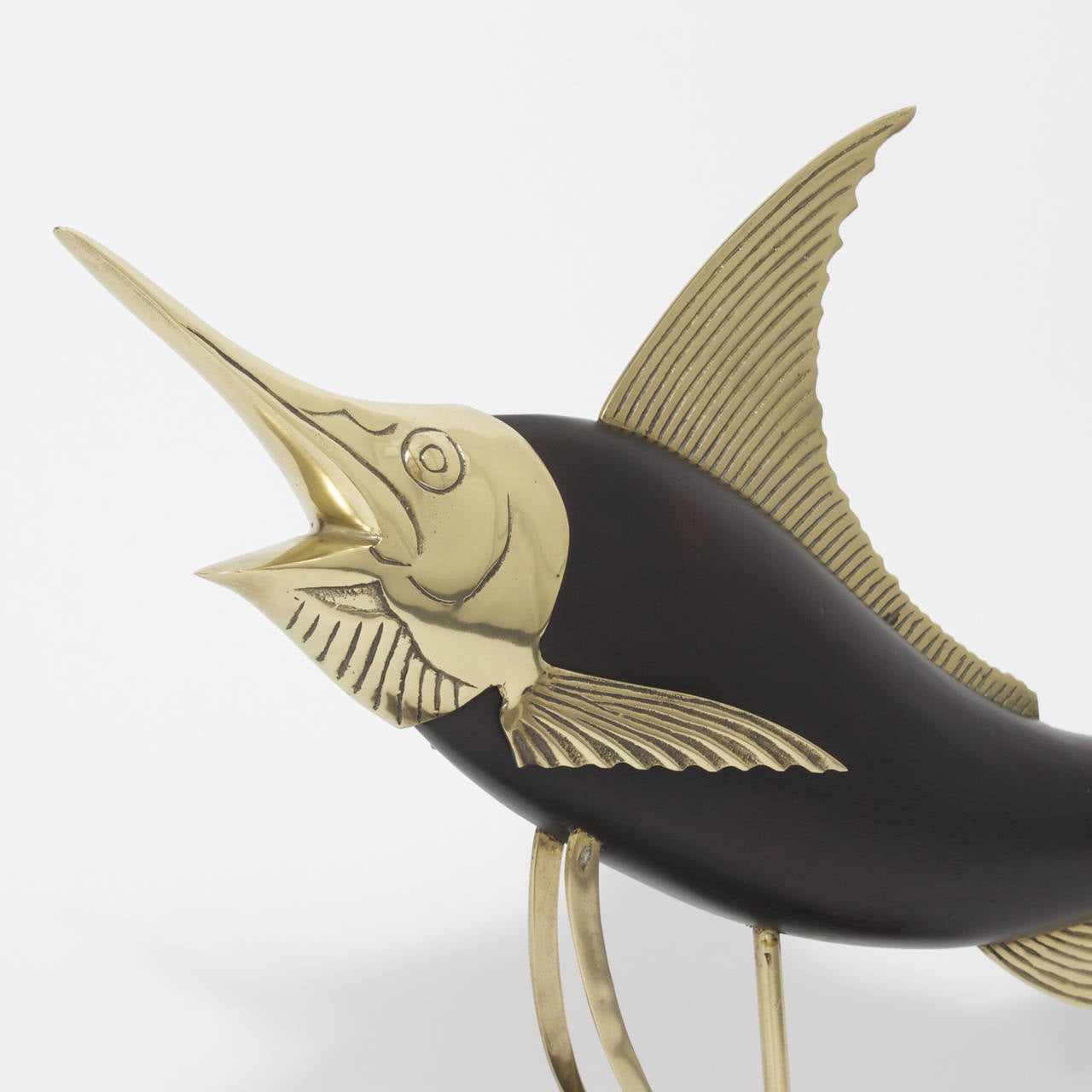 Frederick Cooper carved wood and brass sail fish sculpture posed in a high energy leaping posture, presented on a brass post and wood base. Newly polished.