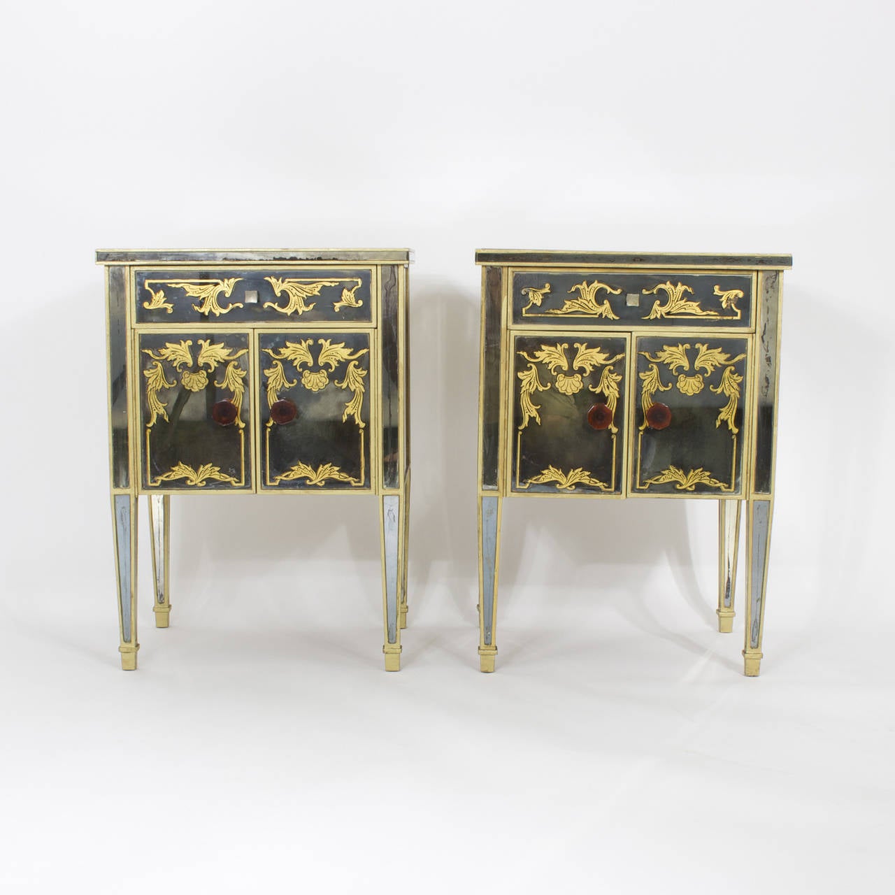 Glamorous, pair of Italian, mid century mirrored nightstands, or tables each with drawers and open storage cabinet doors.  Top, front and sides with reverse painted classical, gold decoration. Over all distressed to perfection.