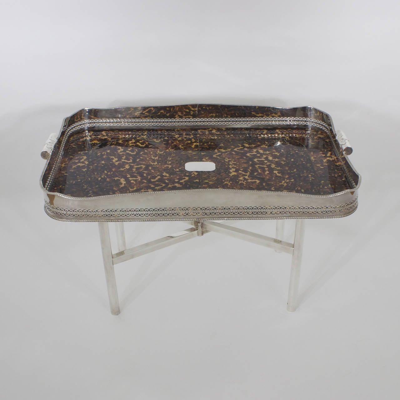 A fine large faux tortoise shell serving tray, tea, coffee, or cocktail table with a prominent silver plated gallery, tooled with intricate fret work, handles decorated with acanthus and center plaque for engraving. This faux tortoiseshell tray is