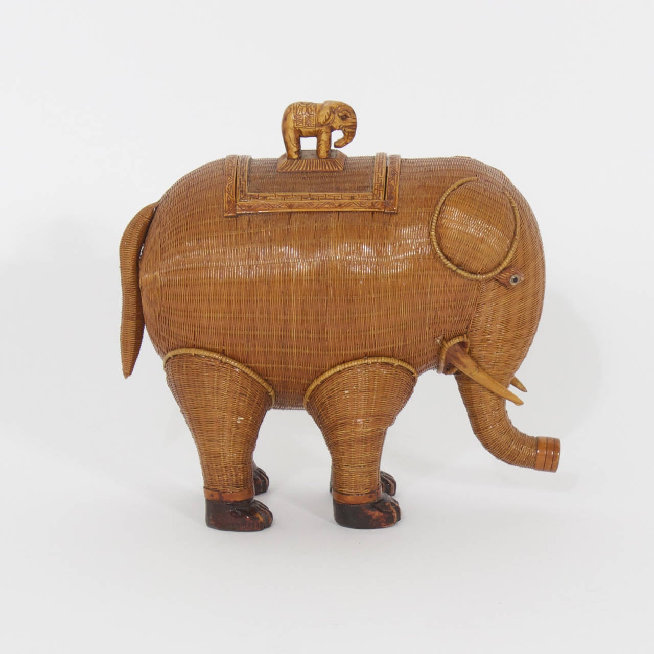 Amusing wicker elephant box constructed with an incredible tight weave, carved wood trim, glass eyes and removable saddle for secret storage. This will put a smile on your face. Works well in all decors, including tropical, campaign, British
