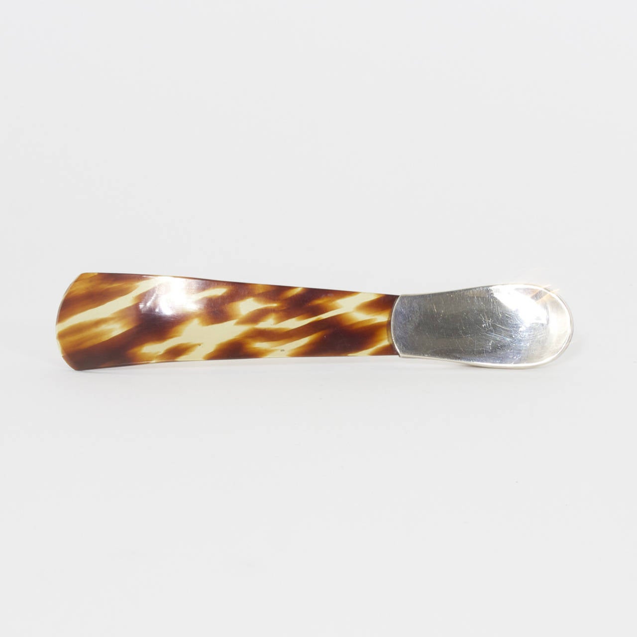 Charming faux tortoise shell and sterling shoe horn in the shape of a ladies low heeled shoe. From a by gone day and stamped sterling 925. Newly polished.
