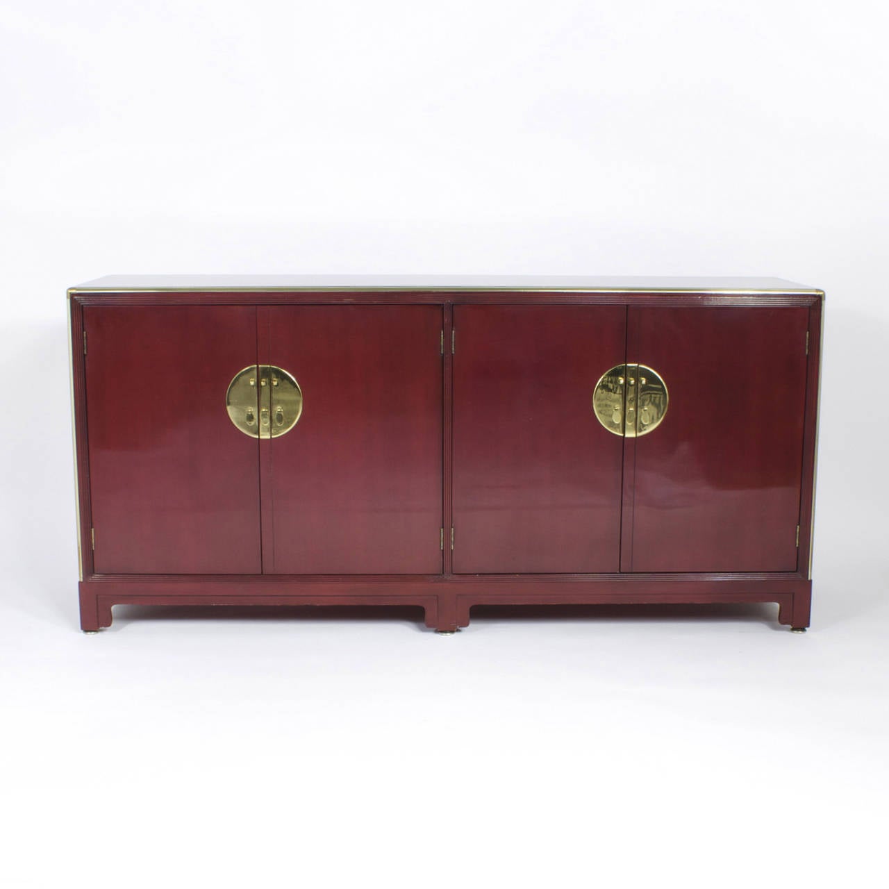 An interesting hybrid of furniture design, really gives new meaning to the phrase “Where East Meets West.” A chic Mid-Century four-door cabinet with a glazed cherry lacquer, brass outlines and with typical baker style textured corners. Featuring