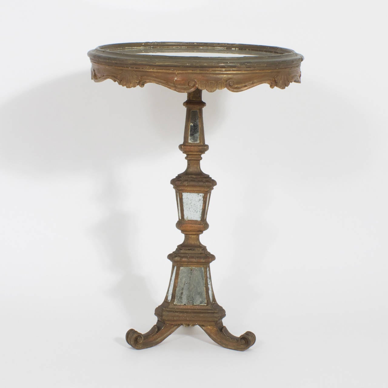 Pair of classical Italian gold painted stands with circular tops that feature inset distressed mirrored glass panels. A skirt with scalloped edges that are decorated with acanthus leaves and scrolls that are fastened to a pedestal with three