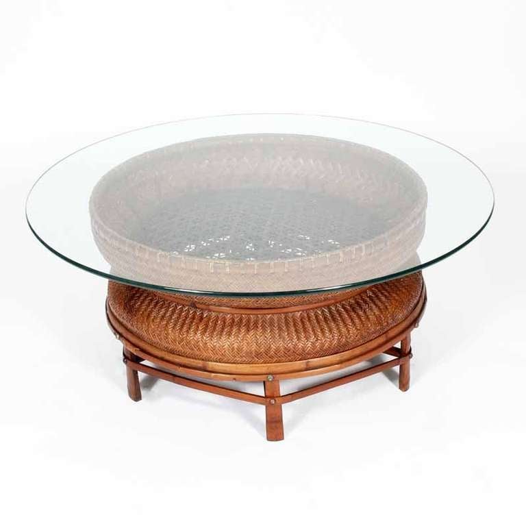 A woven wicker tea collecting basket on a bamboo base, converted to a glass top cocktail or coffee table. Add your favorite collection to the basket, for a decorative 