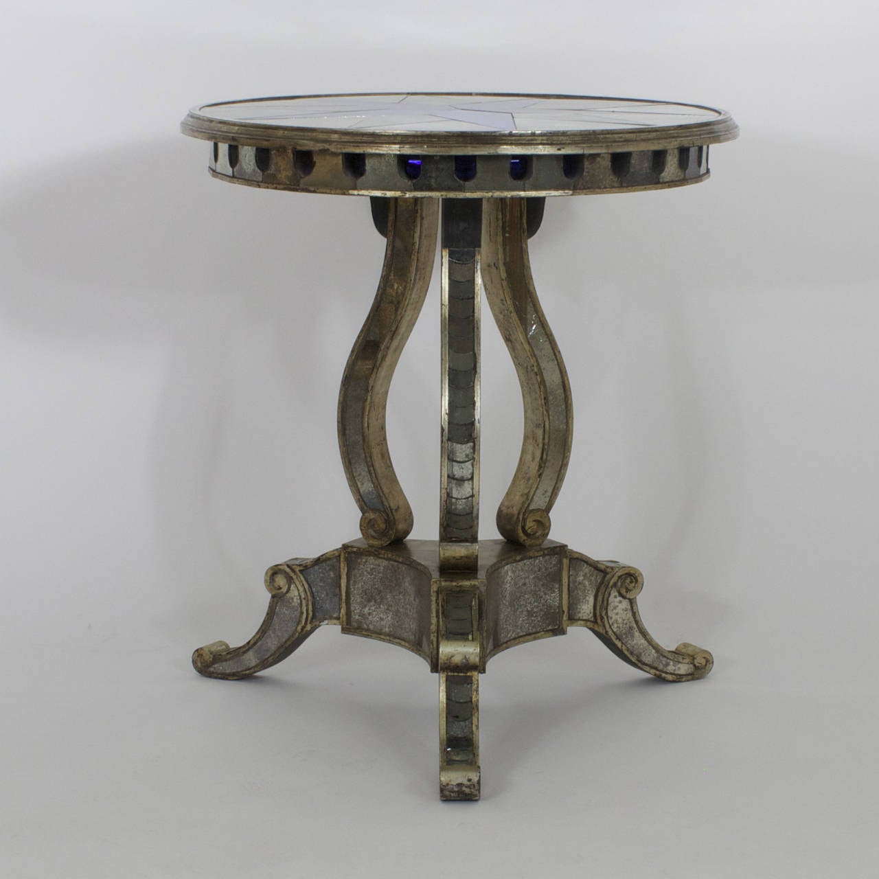 Stunning pair of mirrored end tables that are an intriguing combination of influences. Manufactured in the Mid-Century and drawing from the Italian Renaissance, Regency and Art Deco. The mirrored tops have a blue and silver kaleidoscope pattern