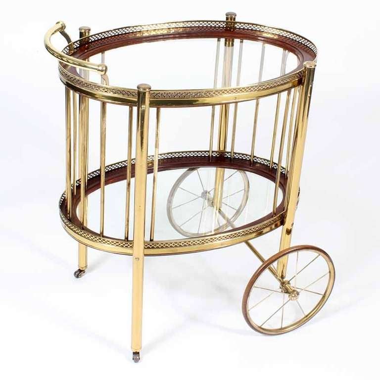A tea cart or serving trolley in brass, with pierced brass gallery, glass shelves, on wheels and casters. Very Hollywood regency in style, and super functional.

fshenemaderantiques.com  - check it out.