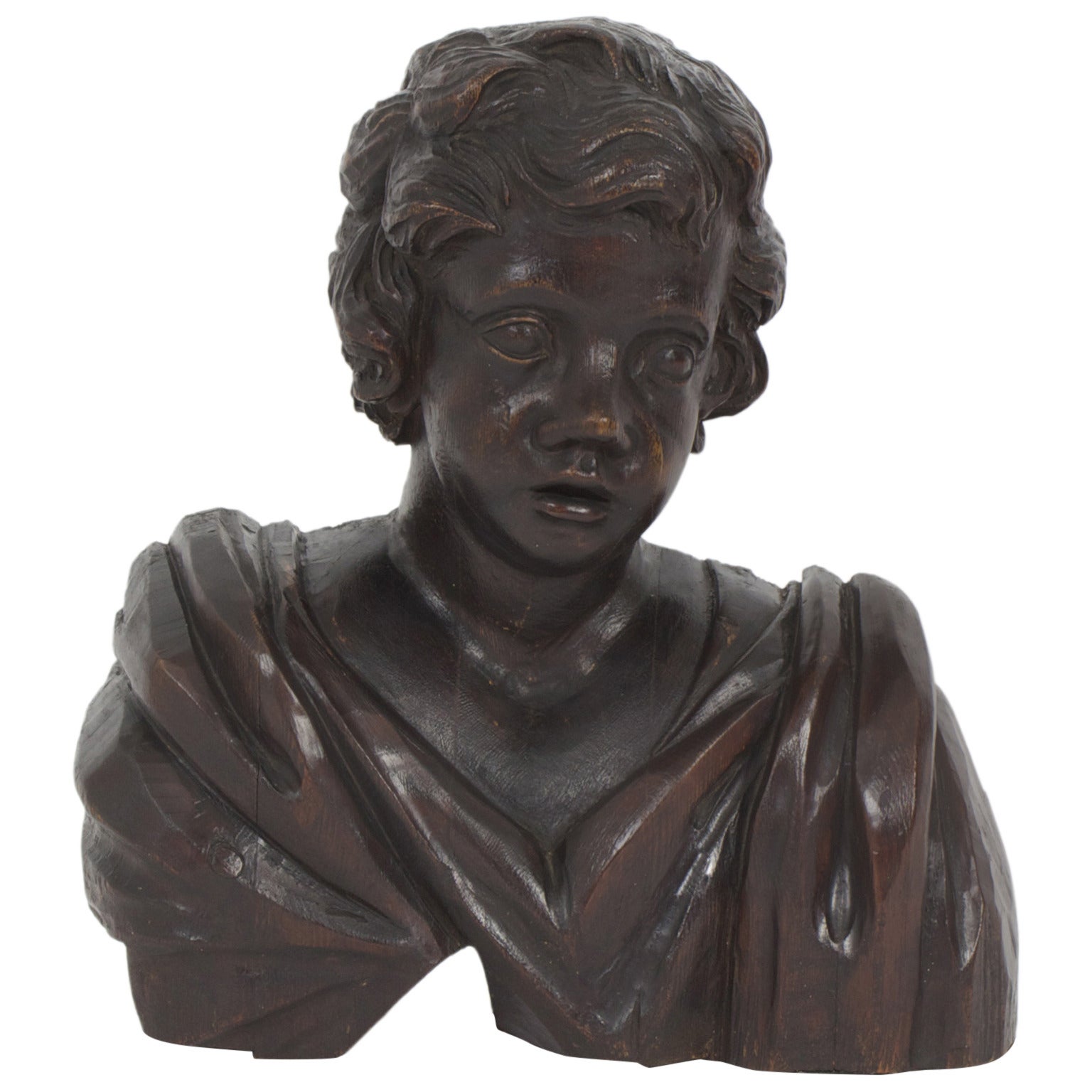 Antique, sculptural wood bust of a young woman or prepubescent child with a haunting, innocent expression. Displays as a wall mount or standing sculpture. Expertly carved hair, face and clothing and an over all dark, mellow mood, reminiscent of
