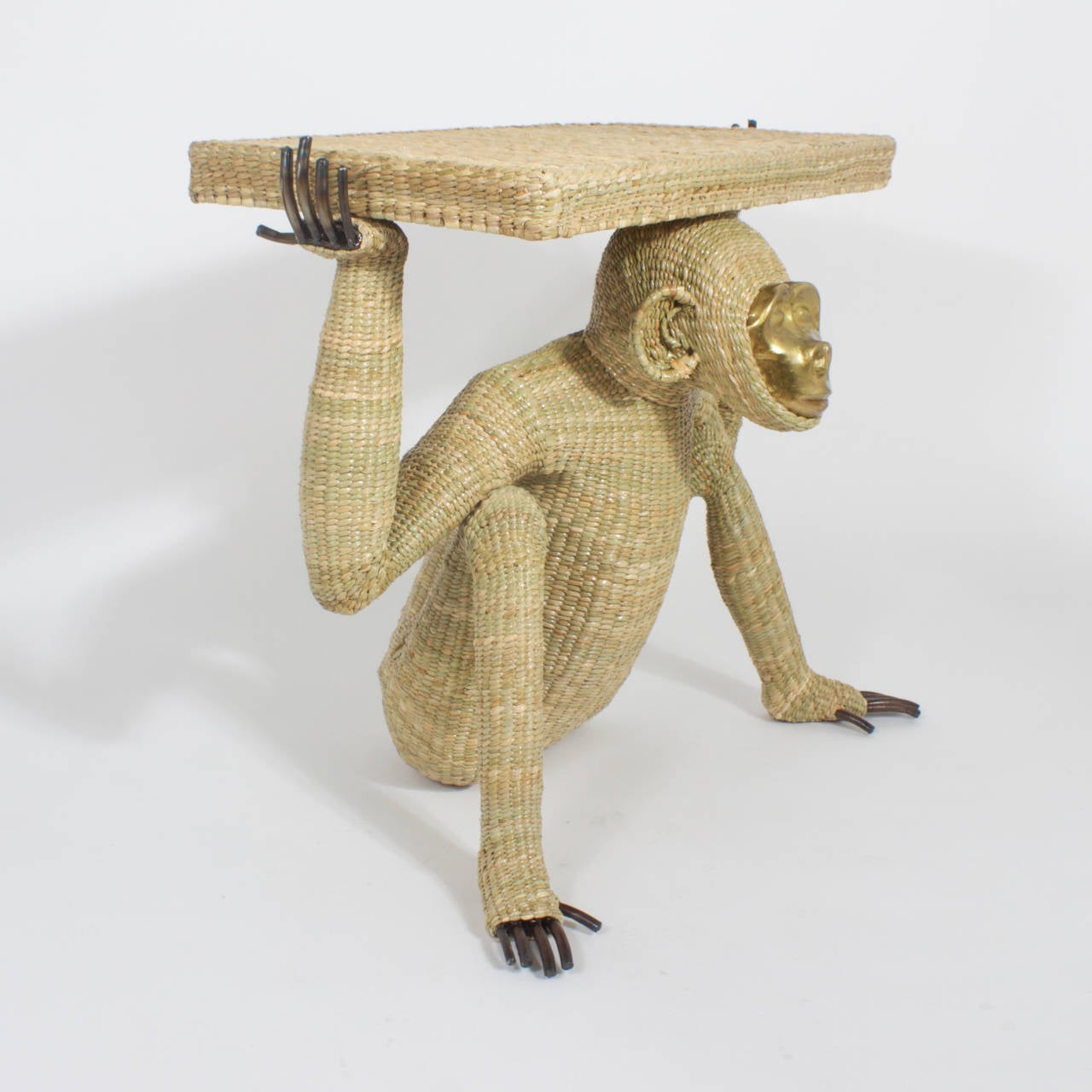 Mario Torres monkey or chimpanzee console constructed with a metal frame expertly wrapped in wicker or reed. Having a pressed brass face and exposed fingers and toes. This would fit right in to a modern interior or be just that right touch of whimsy